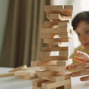 Father And Son Play Block Tower Game Indoors During Daytime