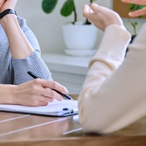 Middle Aged Female Psychologist, Counselor Working With Young Woman Patient